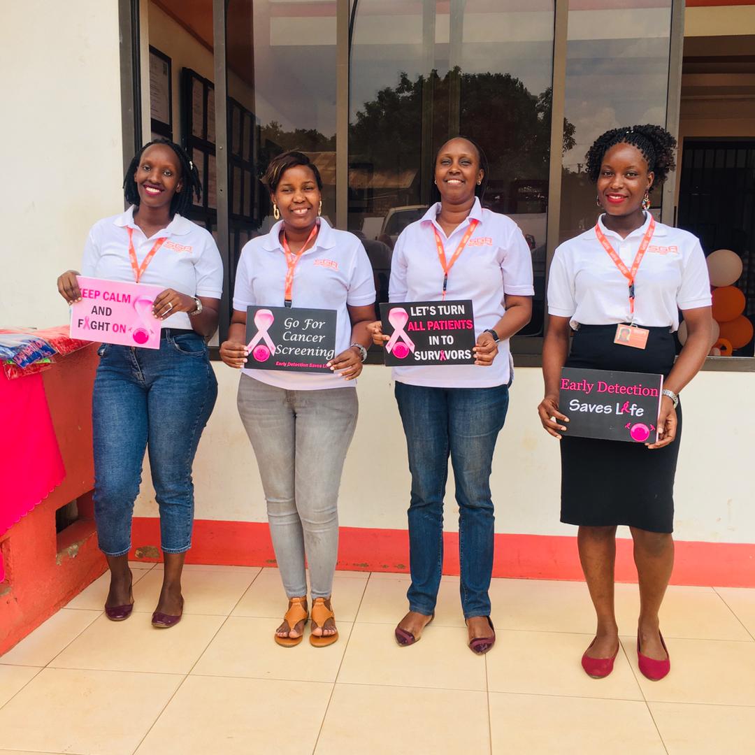 Women standing with placards of advocacy against breast cancer