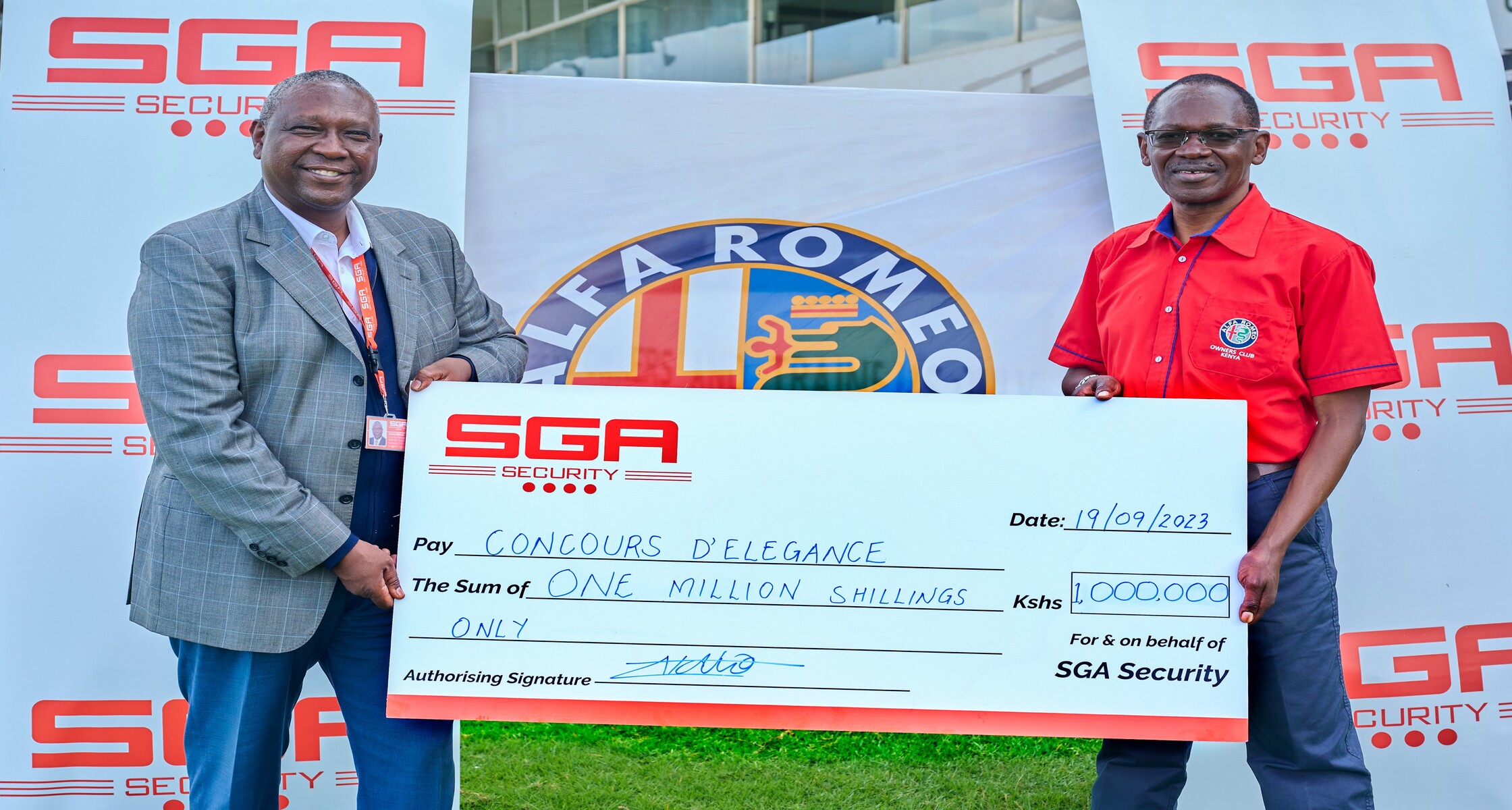 Two men holding cheque and posing