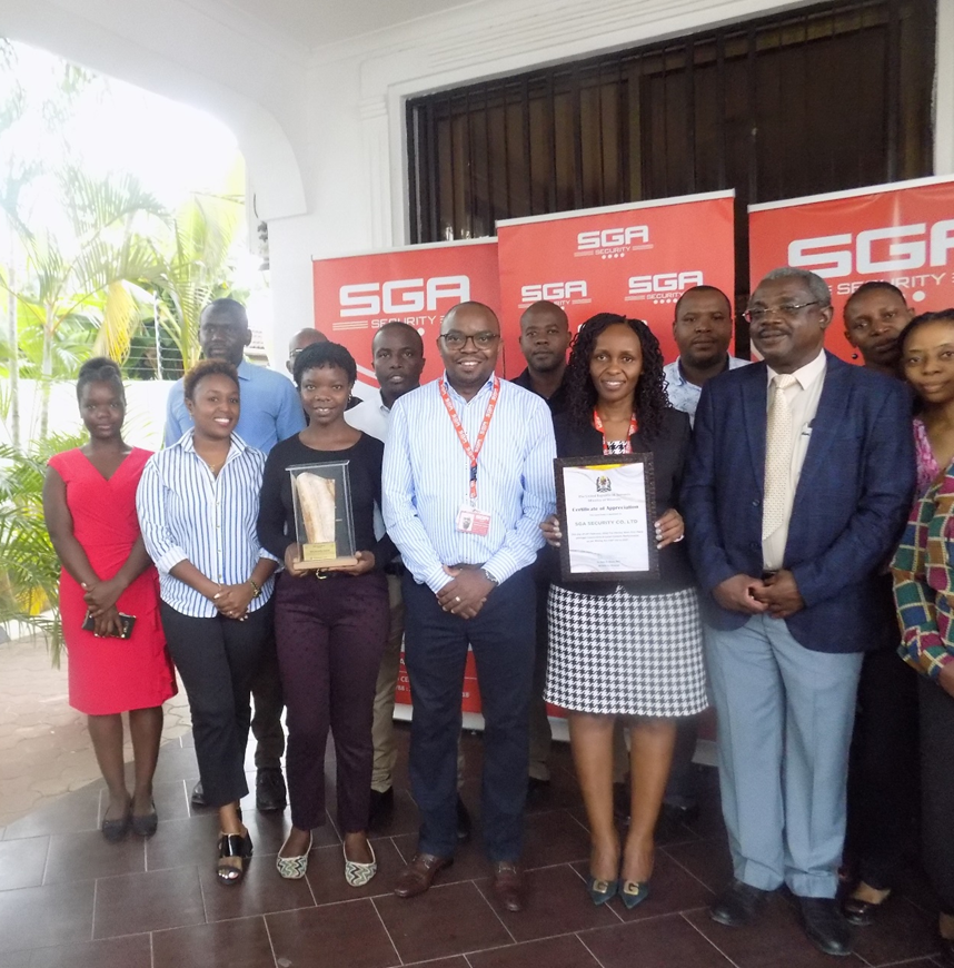 A group posing with trophy and certificate