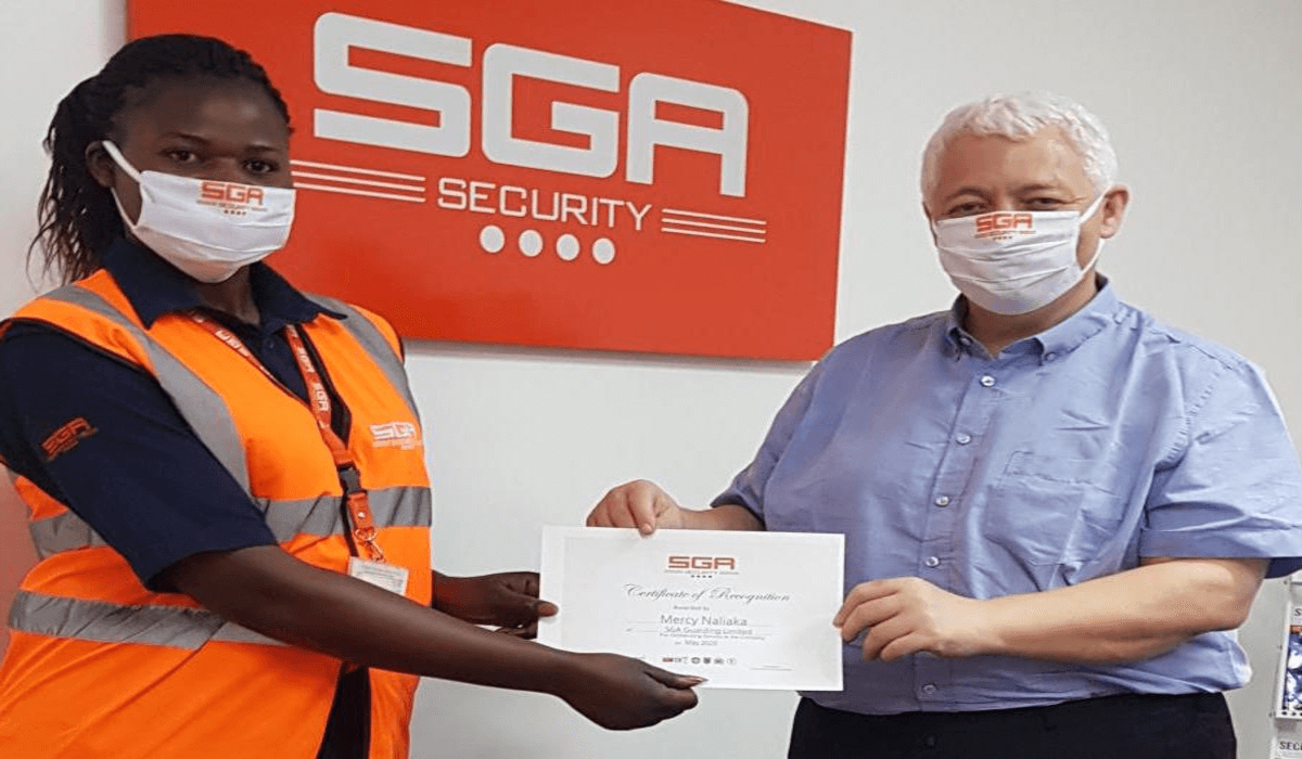 SGA-Security-best-performing-guard-Mercy-Naliaka-receives-a-certificate-and-cash-award-from-the-Country-Director-Jeremy-Van-Tongeren-to-appreciate-role-of-female-guards_jpg.png