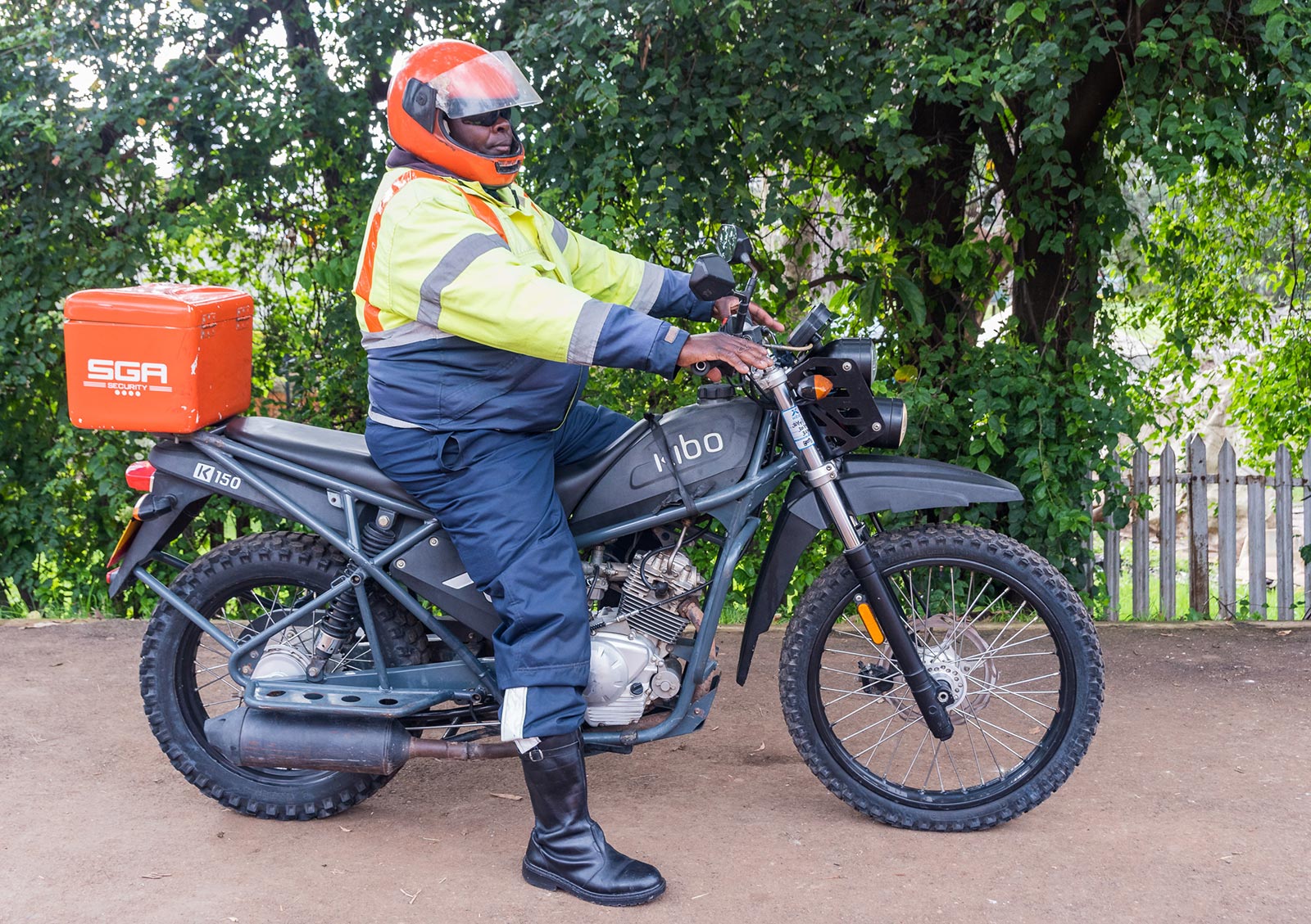 Man on motorbike with a large box marked SGA