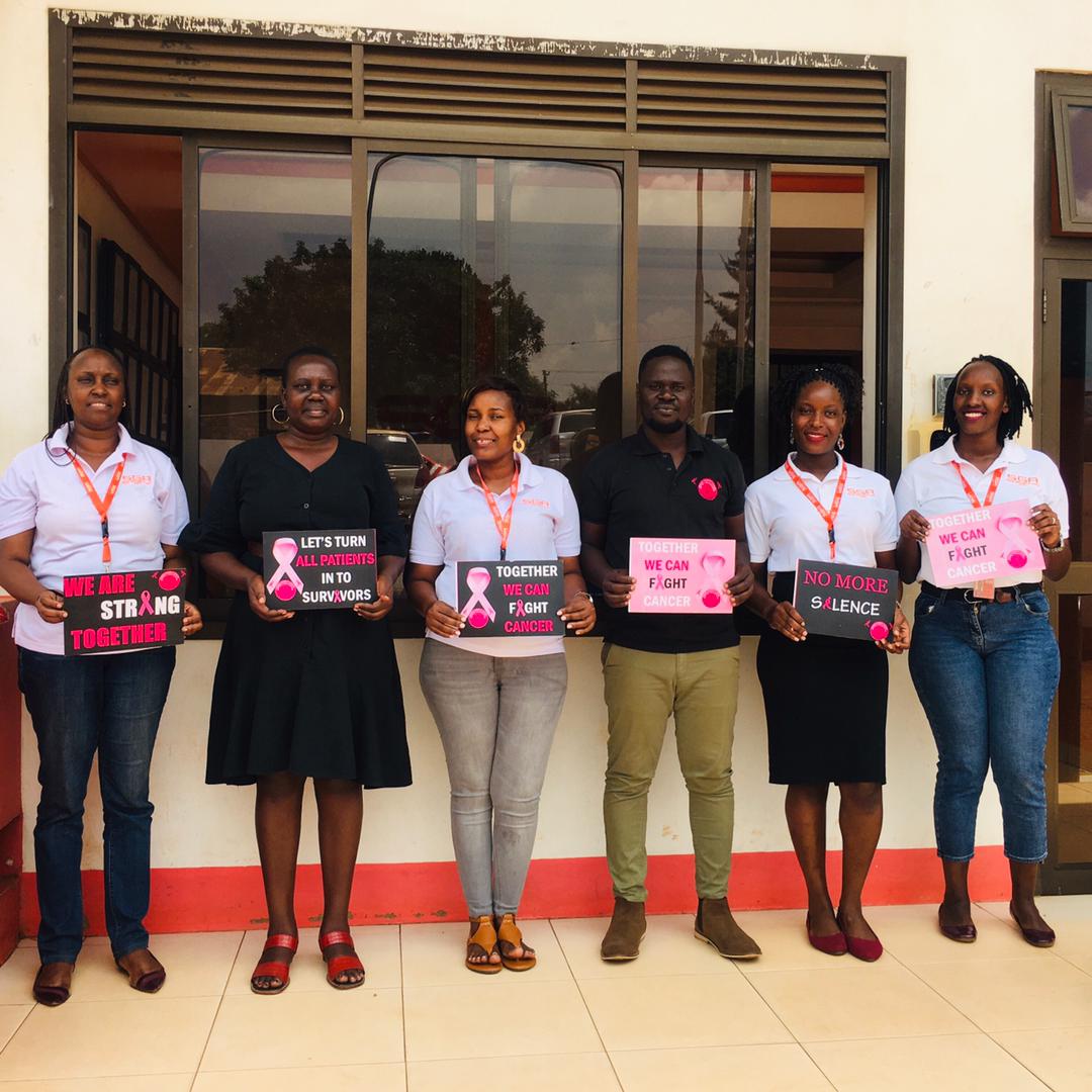 People posing with placards of advocacy against breast cancer