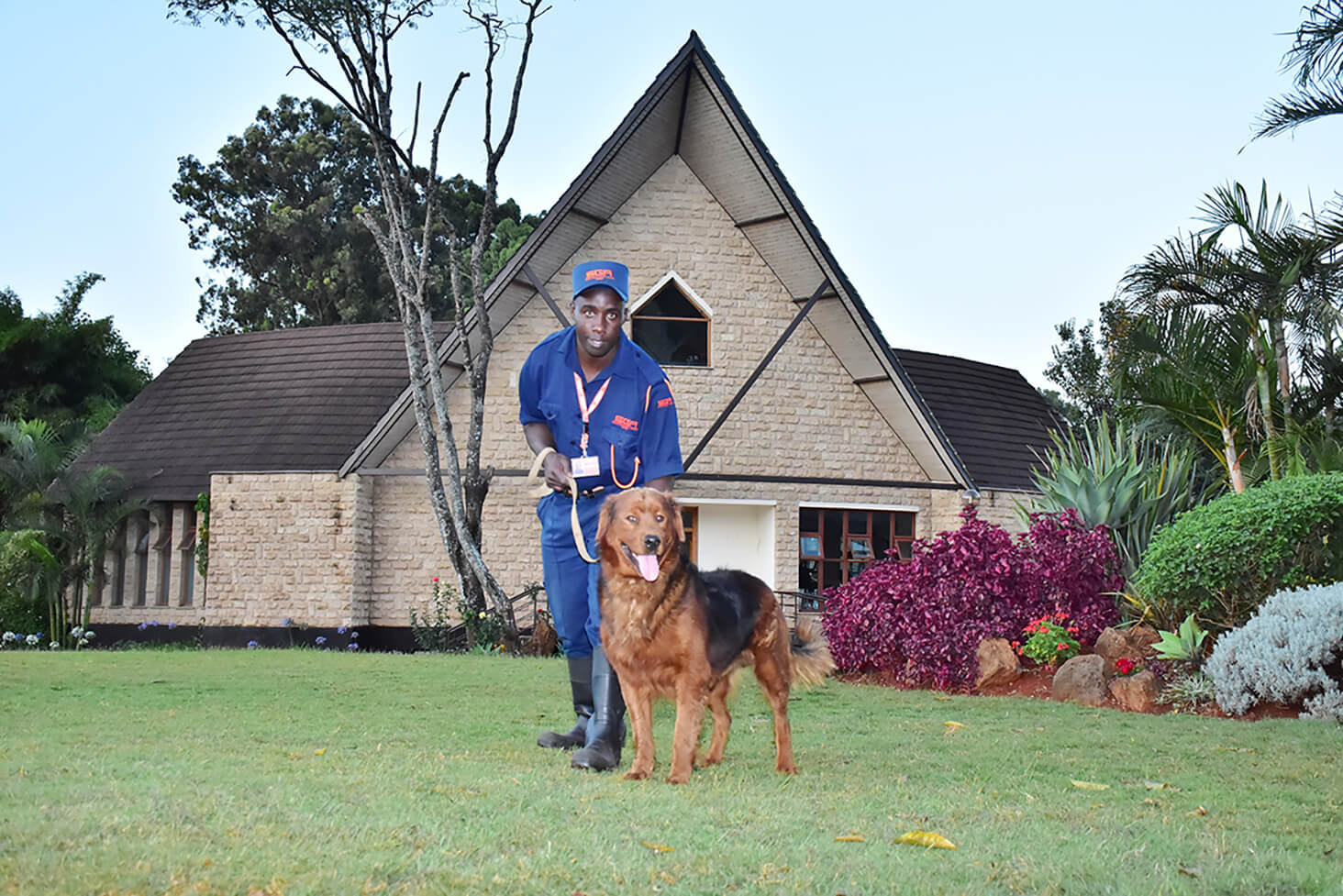 Man and dog pose outside a home that they're protecting