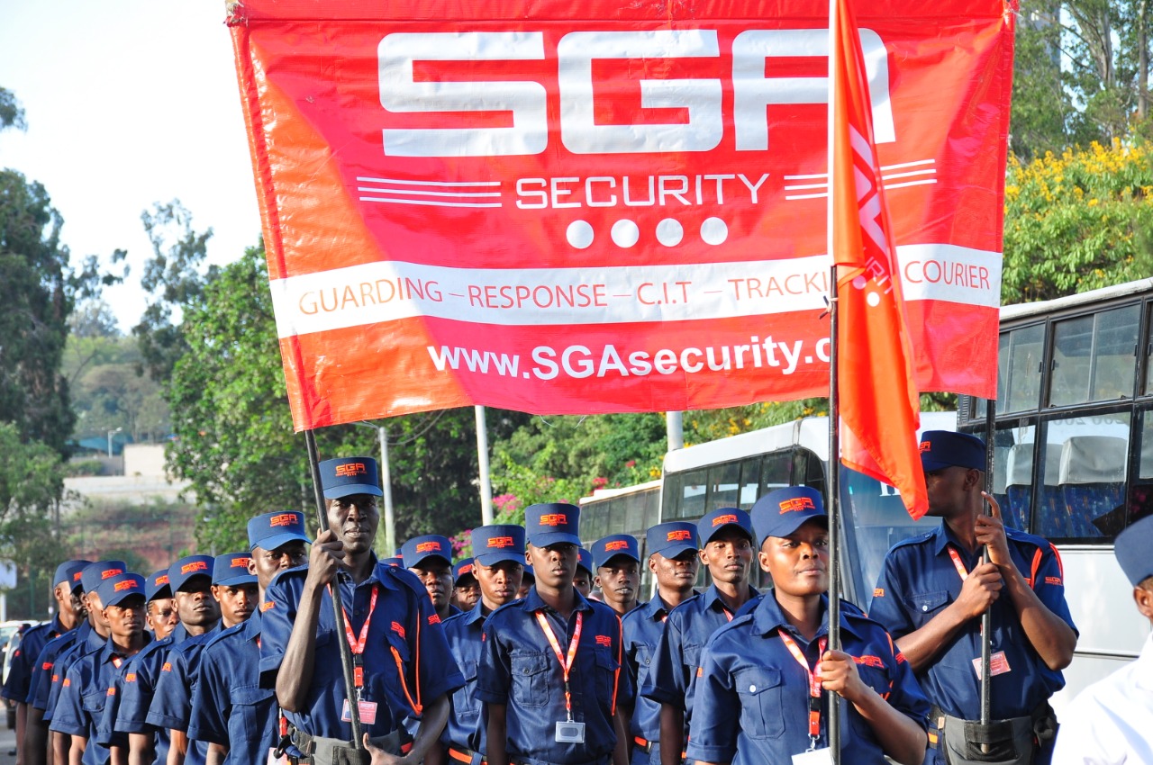SGA Security personnel matching while holding the company flag